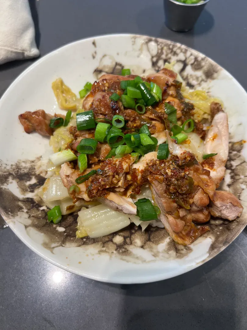 Chicken thighs over cabbage and rice, topped with the chilli oil and scallions